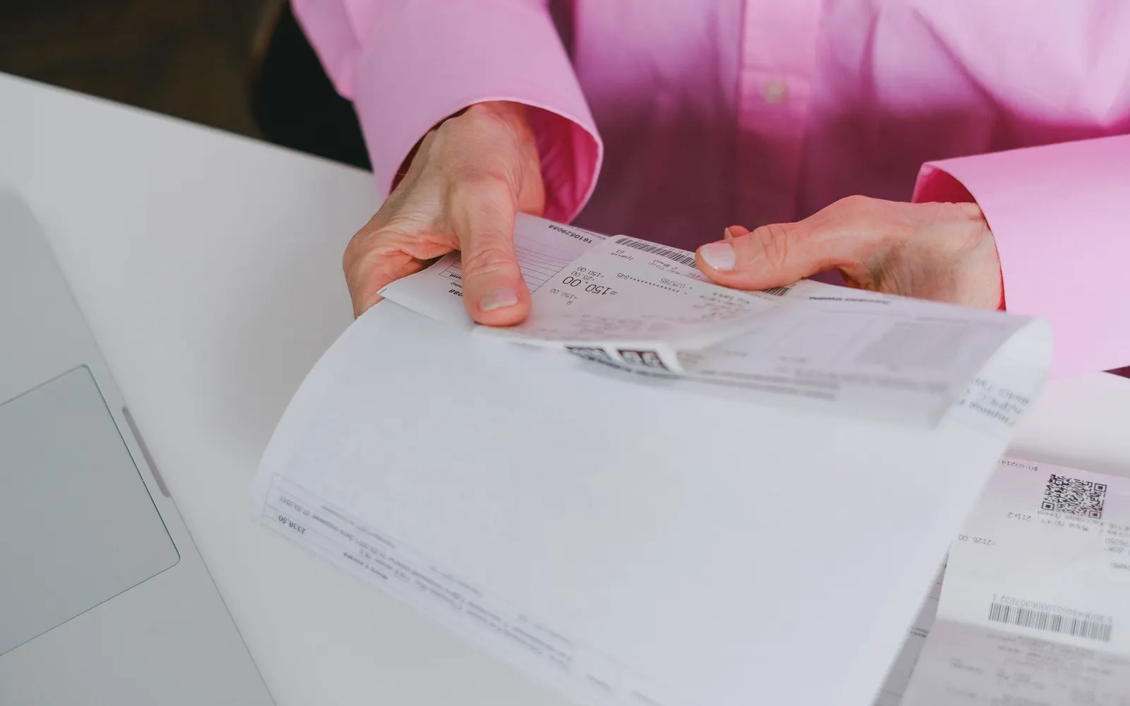 A person reviewing invoices and receipts at a desk