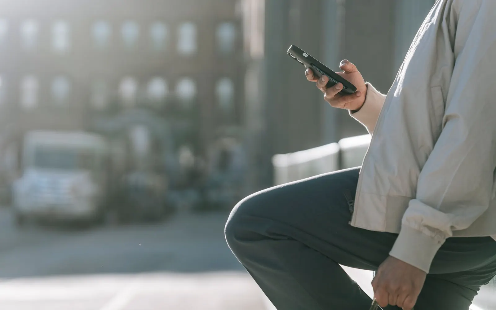 Person checking a phone on a city street — mobile is where a slow website costs you the most