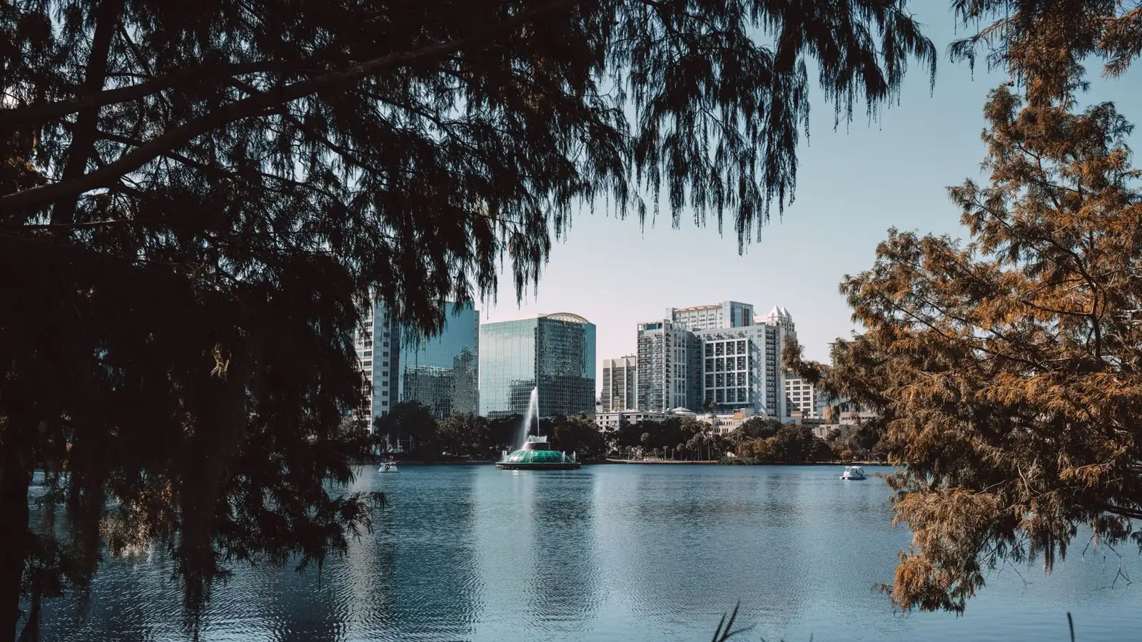 Lake Eola fountain and the downtown Orlando skyline framed by cypress trees