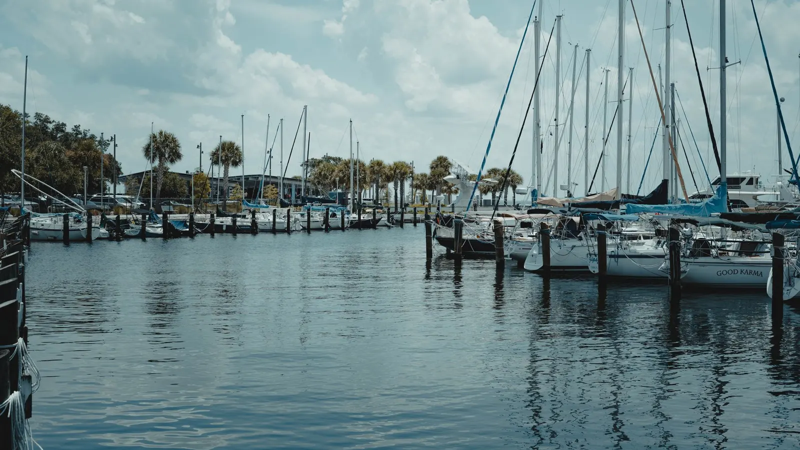 Sailboats docked at a Port St. Lucie marina under summer clouds